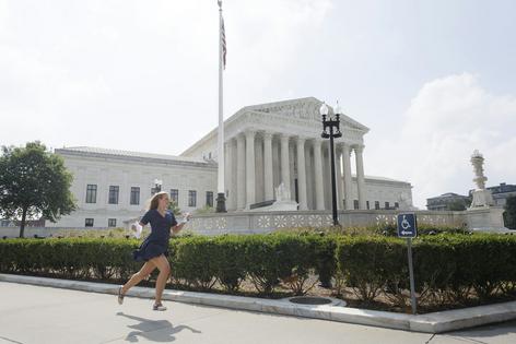 A news reporter carrying printed justice opinion announcements sprints outside U.S. Supreme Court on June 29, 2026, in Washington, DC. Tom Brenner/Getty Images