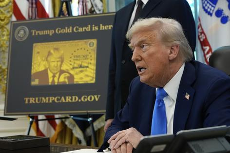 President Donald Trump signs executive orders in the Oval Office next to a poster displaying the Trump Gold Card on Sept. 19, 2025.
              AP Photo/Alex Brandon