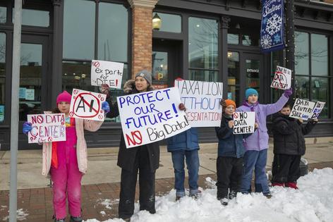 People in Saline, Mich., hold signs opposing a data center proposed in their community.
Jim West/UCG/Universal Images Group via Getty Images