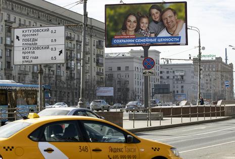 Cars drive past a billboard that reads ‘Let’s preserve traditional values’ in Moscow on March 25, 2020.
              AP Photo/Alexander Zemlianichenko
