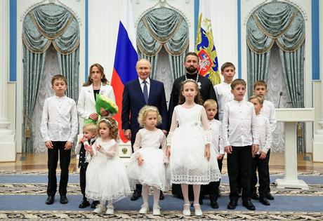 President Vladimir Putin poses with a couple awarded the Order of Parental Glory and their children during a ceremony for large families on International Children’s Day in Moscow on June 1, 2026.
              Alexander Kazakov, Sputnik, Kremlin Pool Photo via AP