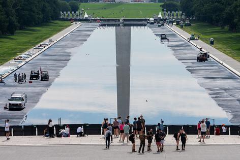 WASHINGTON, DC - JUNE 6: People walk past the Reflecting Pool on the National Mall on June 6, 2026 in Washington, DC. The Trump Administration has repainted and cleaned the Reflecting Pool ahead of the country's 250th anniversary next month. (Photo by Aaron Schwartz/Getty Images)