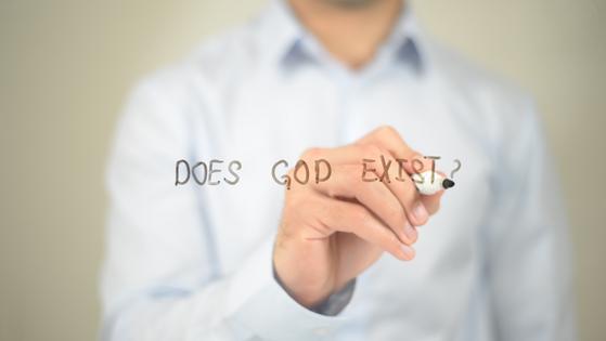 Does God Exist, man writing on transparent screen. Dreamstime/TCA