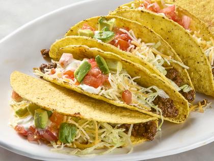 Hard-shell tacos with taco-spiced filling, shredded cheese, lettuce and sour cream. (Alex Lepe/TCA)