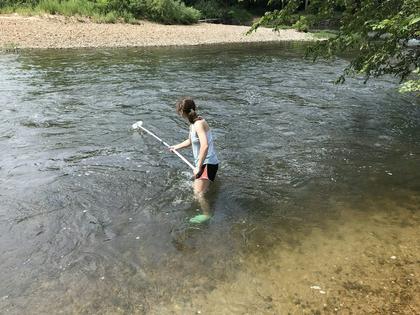 A student collects a water sample for DNA analysis. David Duvernell, CC BY
