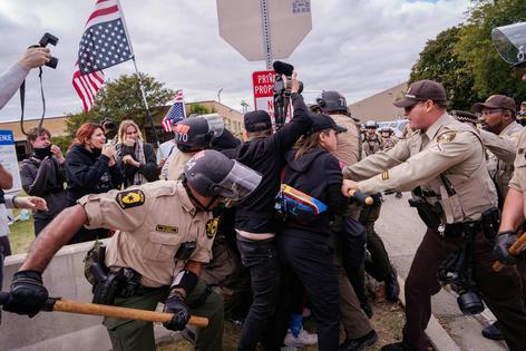 Officers detain protesters outside a U.S. Immigration and Customs Enforcement facility in Illinois on Oct. 11, 2025.
              AP Photo/Adam Gray