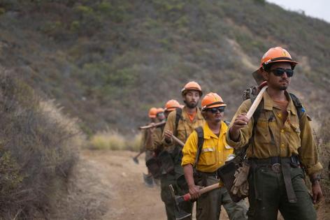 Fighting wildfires often means walking miles in steep terrain, carrying the equipment and protective gear firefighters need. These firefighters are working on the Timber Fire near Big Sur, Calif., in August 2026.
Andrew Avitt/U.S. Forest Service