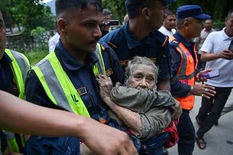 Rescue personnel carry a person caught in the flash flood in Devghat, Nepal, on Aug. 26, 2026.
              Prakash Mathema/AFP via Getty Images