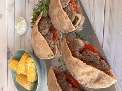 Enjoy smashed lamb burgers tucked into warm pita, served with sweet corn and creamy cucumber whipped feta. (JeanMarie Brownson/TCA)