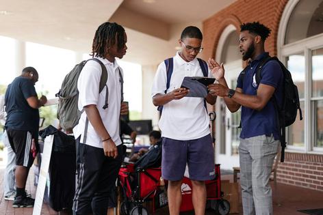 Marchellos Scott, right, helps Morehouse College students fill out a voter registration form at a college registration booth on Aug. 19, 2024, in Atlanta.
              Elijah Nouvelage/AFP via Getty Images