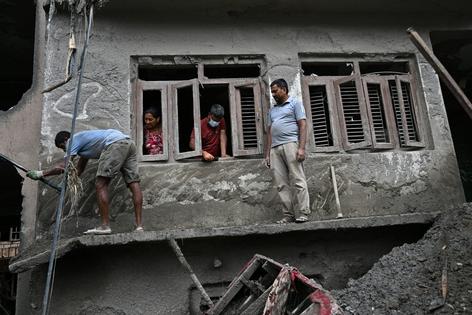 People in the town of Devighat try to clean a home that was covered by the landslide’s debris.
Pedro Pardo/AFP via Getty Images