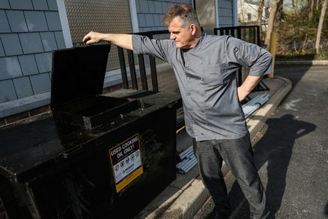 A restaurant owner looks at a tank for collecting used cooking oil. Steve Pfost/Newsday RM via Getty Images