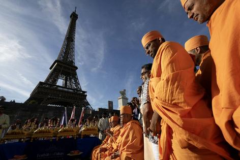 Monks from Bochasanwasi Akshar Purushottam Swaminarayan Sanstha, a Hindu group, take part in a religious ceremony in front of the Eiffel Tower  in Paris on Sept. 3, 2026. Kenzo Tribouillard / AFP via Getty Images