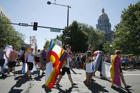 People in a gay pride parade pass by the Colorado State Capitol in Denver on June 19, 2016.
              AP Photo/Brennan Linsley