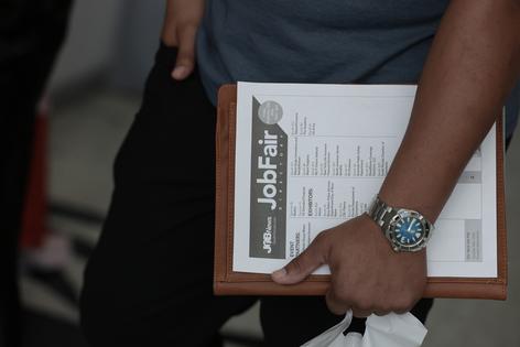 A job seeker holds paperwork during the Mega JobNewsUSA South Florida Job Fair held in the Amerant Bank Arena on Sept. 25, 2026, in Sunrise, Fla. Hiring managers and recruiters from more than 50 companies attended the job fair to recruit workers for opportunities across a range of companies. (Joe Raedle/Getty Images/Tribune Content Agency)