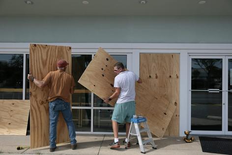 Owners of an ice cream shop board up their windows in Gulf Breeze, Fla., on Oct. 8, 2026, ahead of Hurricane Isaias. Joe Raedle/Getty Images