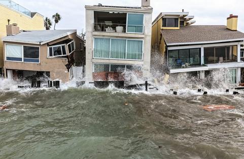 Waves crash into damaged homes in Long Beach, Calif., amid high surf generated by Tropical Storm Rachel on Oct. 11, 2026. Mario Tama/Getty Images