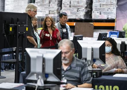 An election integrity officer, in red, trains poll watchers at the Orange County Registrar of Voters in Santa Ana, Calif., on Nov. 1, 2022. Television monitors display what each employee is looking at on their desk for observers to watch.
Paul Bersebach/MediaNews Group/Orange County Register via Getty Images
