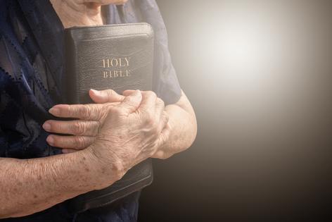 Woman holding Bible. Dreamstime/TCA