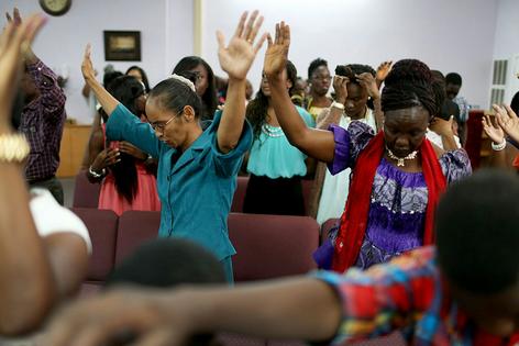 Parishioners pray during a service at New Life Fellowship Church, which has many members from Liberia, in Euless, Texas, in 2014.
              Joe Raedle/Getty Images