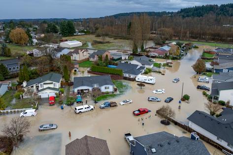 Days of heavy rain broke levees in the Seattle area, engulfing this neighborhood in floodwater on Dec. 16, 2025. More Americans are experiencing extreme weather firsthand and connecting it to climate change.
              Brandon Bell/Getty Images