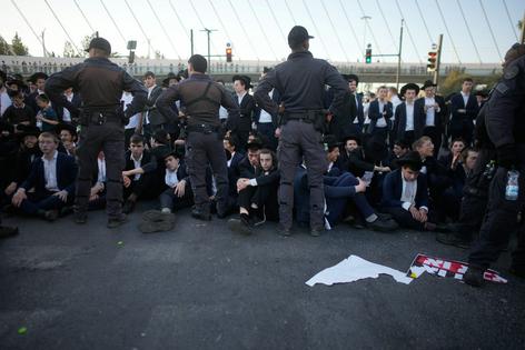 Israeli police disperse ultra-Orthodox Jews blocking a road during a protest against the army draft in Jerusalem on Oct. 8, 2026. AP Photo/Ohad Zwigenberg