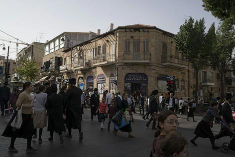 People walk the streets of the ultra-Orthodox neighborhood Mea Shearim in Jerusalem, Israel, on April 18, 2024.
              AP Photo/Leo Correa