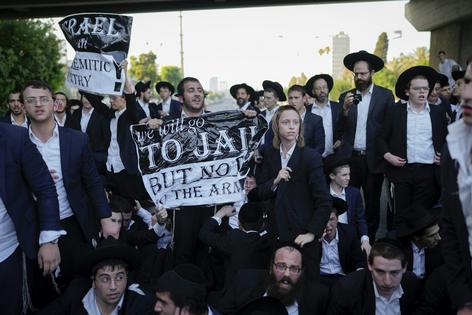 Ultra-Orthodox Jewish men protest military recruitment by blocking a road in Bnei Brak, near Tel Aviv, Israel, on July 16, 2024.
              AP Photo/Ohad Zwigenberg
