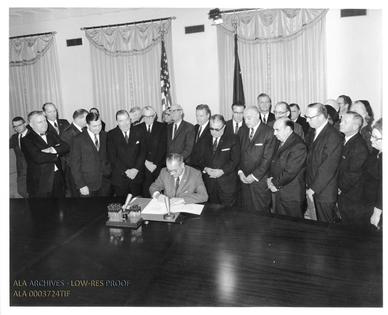 President Lyndon Johnson signs a 1964 law expanding federal aid to libraries.
              Cecil W. Stoughton/The American Library Association Archives