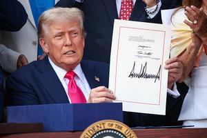 U.S. President Donald Trump, joined by Republican lawmakers, signs the One, Big Beautiful Bill Act into law during an Independence Day military family picnic on the South Lawn of the White House on July 4, 2025, in Washington, D.C. (Samuel Corum/Getty Images/TNS)