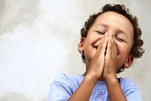 Little boy praying to God. Dreamstime/TCA