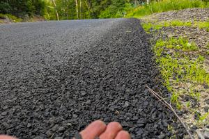 This rural road near my house was just coated with small stone chips embedded in a thin layer of asphalt cement. You can do the same thing on your driveway. (Tim Carter/Tribune Content Agency/TNS)