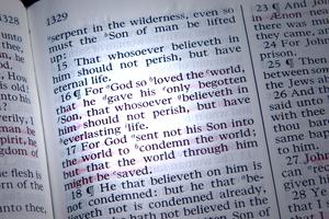 Bible is opened to John 3:16, highlighted by a beam of light. Dreamstime/TCA