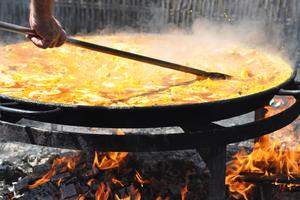 A man is cooking a huge paella, a Spanish traditional dish, at the beach (Nerja, Malaga) in the old-fashioned way. Dreamstime/TCA