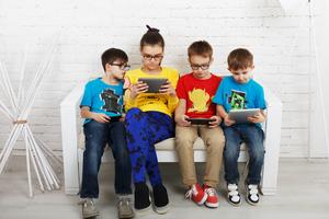 Children obsessed with their electronic devices. Dreamstime/TCA
