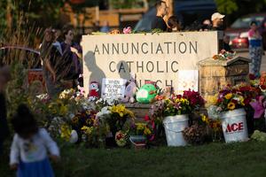 MINNEAPOLIS, MINNESOTA - AUGUST 28: People leave flowers and other mementoes in front of Annunciation Catholic Church, a rapidly growing memorial to the victims of yesterday's shooting on August 28, 2025 in Minneapolis, Minnesota. A gunman fired through the windows of the church while students were sitting in pews during a Catholic school Mass, killing two children and injuring at least 17 others. The gunman reportedly died at the scene from a self-inflicted gunshot wound, according to police. (Photo by Scott Olson/Getty Images)