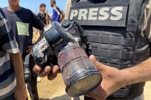 A journalist holds the blood-covered camera belonging to Palestinian photojournalist Mariam Dagga, a journalist who freelanced for AP since the start of the war and who was killed in an Israeli strike on Nasser hospital in Khan Yunis in the southern Gaza Strip, during her funeral on August 25, 2025. Gaza's civil defence agency said five journalists, including Mariam Dagga, were among at least 20 people killed on August 25 when Israeli strikes hit Nasser hospital in the south, with Reuters, the Associated Press and Al Jazeera mourning their slain contributors. (Photo by AFP). AFP via Getty Images