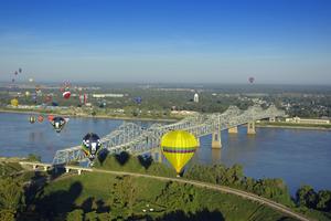 Hot Air Balloons Over Mississippi River. Hot air balloons flying over the Mississippi River toward Louisiana at Natchez, MS. Dreamstime/TCA
