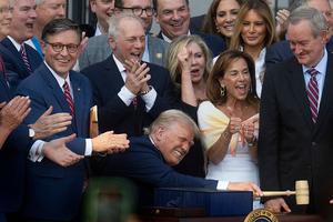 US President Donald Trump bangs a gavel after signing his signature bill of tax breaks and spending cuts 