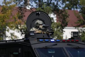 An armed law enforcement agent sits in an armored vehicle as residents of Chicago's Brighton Park neighborhood confront law enforcement at a gas station after Immigration and Customs Enforcement (ICE) agents allegedly detained an unidentified man riding in his car, in Chicago, Illinois, on Oct. 4, 2025. U.S. President Donald Trump, who campaigned on a pledge to deport large numbers of migrants, has encouraged authorities to be more aggressive as he seeks to hit his widely reported target of one million deportations annually. (Octavio Jones/AFP via Getty Images/TCA)