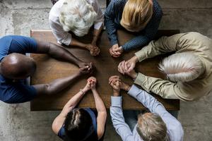 Group of people praying. Dreamstime/TCA