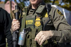 U.S. Border Patrol Cmdr. Gregory Bovino carries tear gas, a rifle and a body camera while conducting immigration enforcement operations on Oct. 31, 2025, in Chicago’s Edison Park neighborhood. (Brian Cassella/Chicago Tribune/TNS)