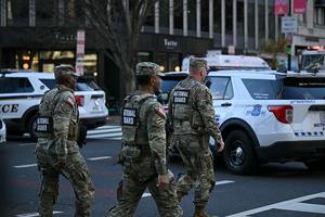 National Guard soldiers gather near a crime scene after a shooting in downtown Washington, DC, on November 26, 2025. Two members of the National Guard were shot Wednesday just blocks from the White House, according to officials, as a spokesperson for Donald Trump said the president has been briefed on the 
