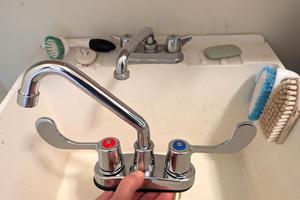 Tim Carter is holding a new laundry tray faucet with paddle handles. You can install one yourself in less than 30 minutes with a few inexpensive tools. (Tim Carter/Tribune Content Agency)