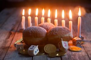 Jewish holiday Hanukkah symbols – menorah, doughnuts, chocolate coins and wooden dreidels. Dreamstime/TCA