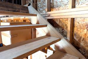 The flat stair treads shown here are mortised into the angled 2x12 board known as a stair stringer. Stringers serve the same purpose as the floor joists in your home. (Tim Carter/Tribune Content Agency)