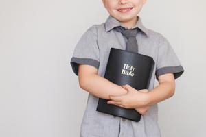 Boy holding Holy Bible. Dreamstime/TCA