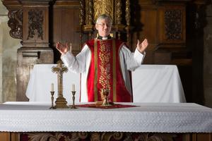 Christian priest blessing the hosts and chalice in a 17th-century church. Dreamstime/TCA