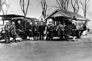 Coast Guardsmen stand in front of two truckloads of liquor seized on April 14, 1931, after a battle between three policemen and several alcohol smugglers near Falmouth, Mass. AP Photo
