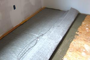 This is one way to add extra heat to your home. This gray mat contains electrical heating cables that make the floor toasty warm sans crumbs! (Tim Carter/Tribune Content Agency/TNS)